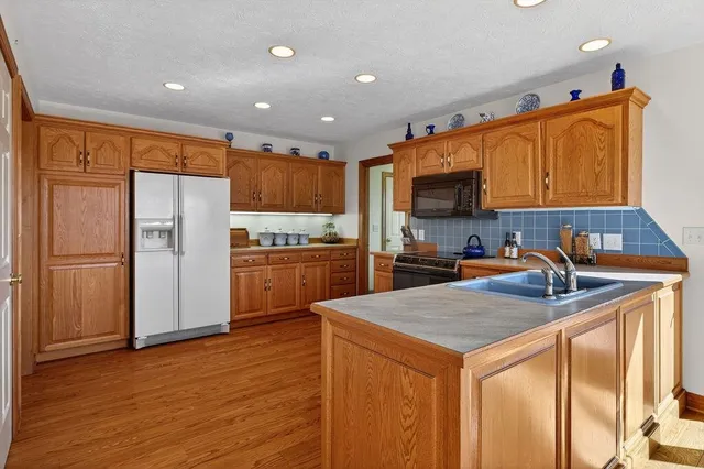 a kitchen with granite countertop cabinets and wooden floor