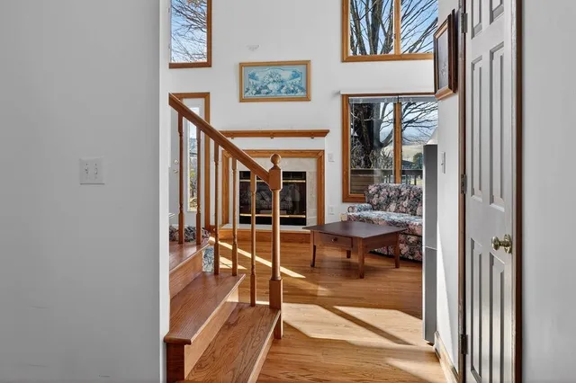 a view of an empty room with wooden floor and a fireplace