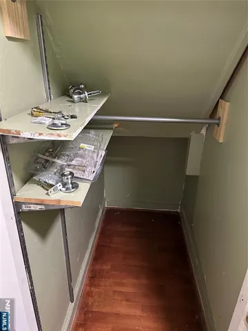 a view of a room with wooden floor and a window