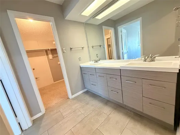 a spacious bathroom with a double vanity sink and a mirror
