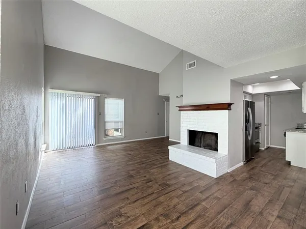 a view of an empty room with a fireplace and a window