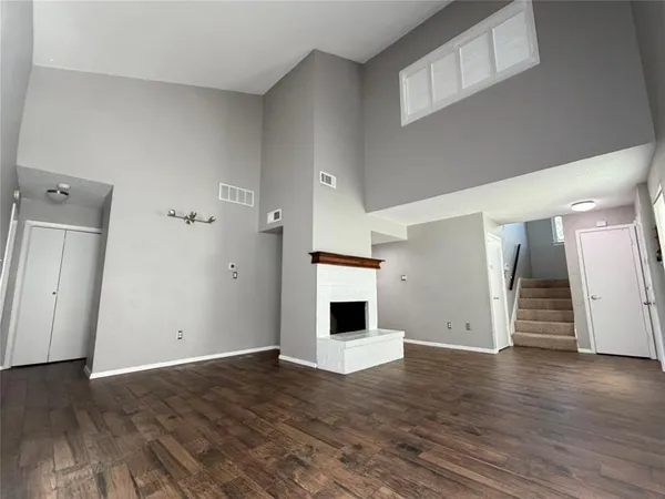 an empty room with wooden floor and fireplace