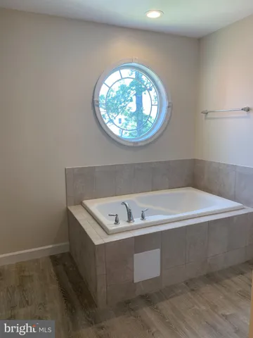 a bathroom with a bathtub and a window