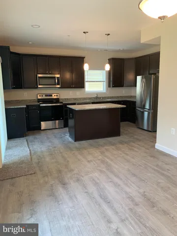 a large kitchen with a large counter top stainless steel appliances and cabinets