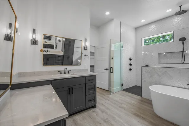 a bathroom with a tub sink and mirror