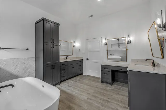 a bathroom with a tub sink toilet and mirror