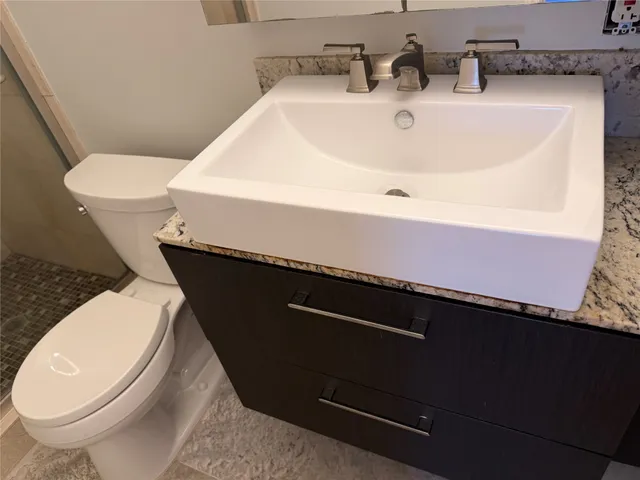 a bathroom with a sink a toilet and a mirror