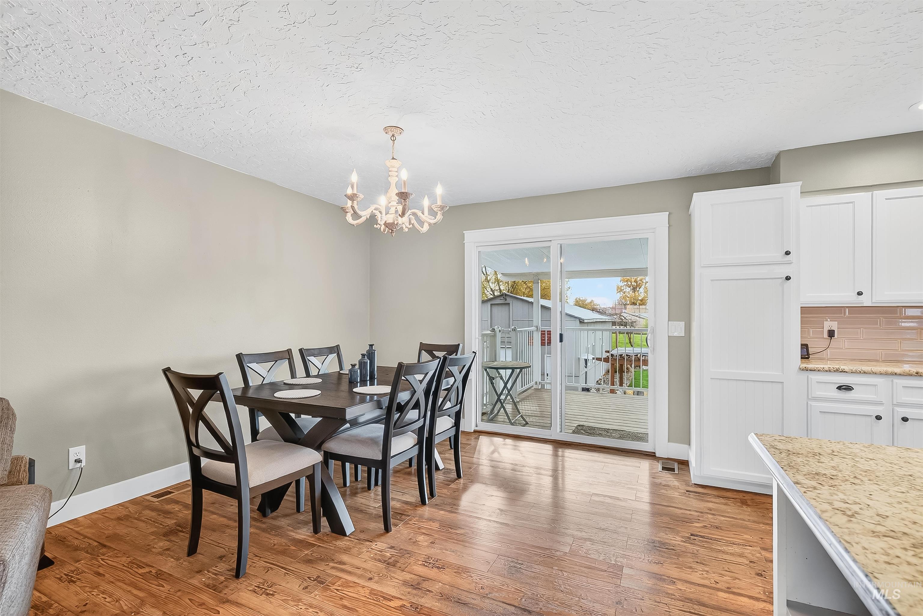 1220 Birch Avenue Lewiston, ID 83501 - Photo 10 of 45 Dining room featuring light wood-type flooring, a textured ceiling, and a chandelier