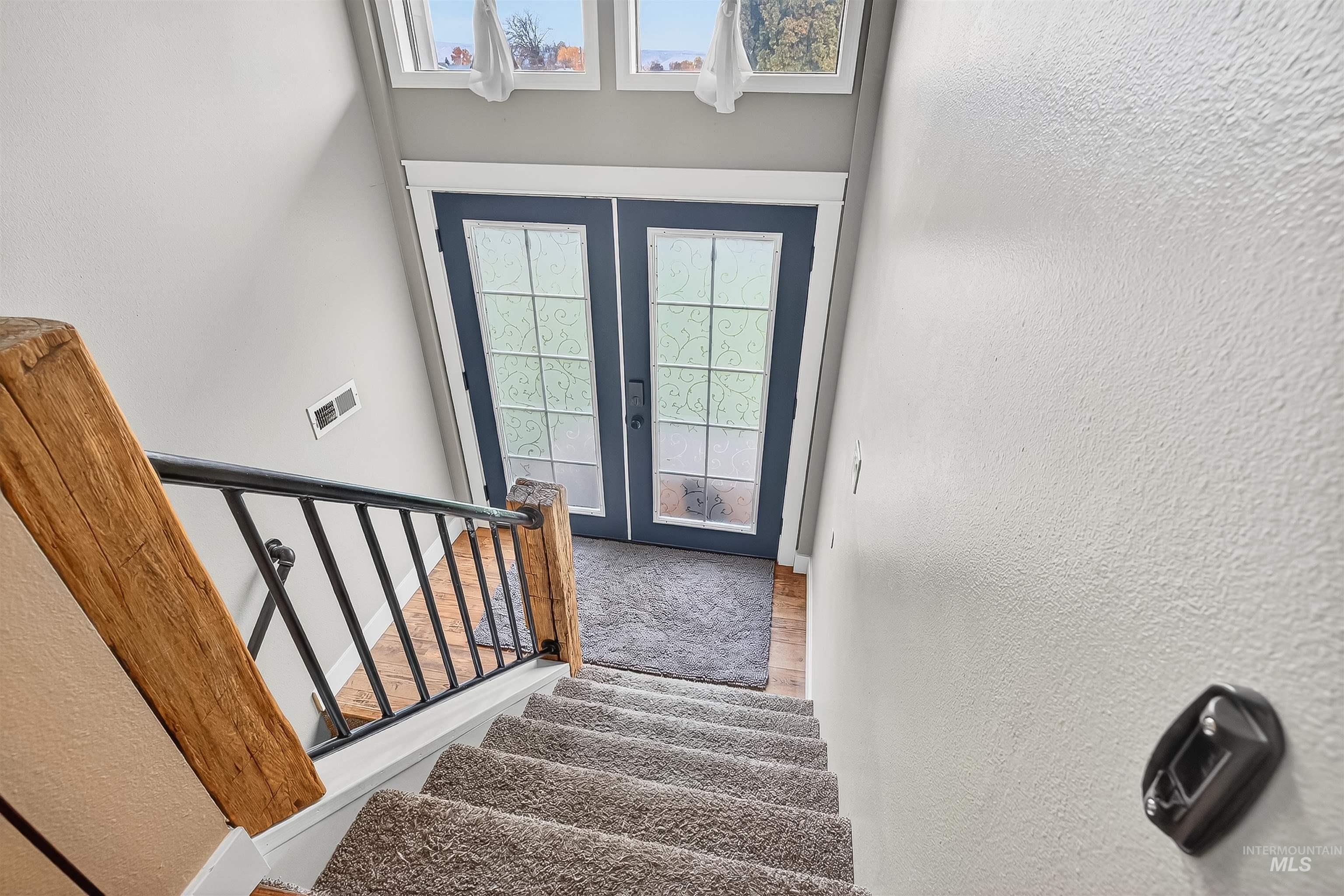 1220 Birch Avenue Lewiston, ID 83501 - Photo 20 of 45 Stairway with a textured wall, french doors, healthy amount of natural light, and wood finished floors
