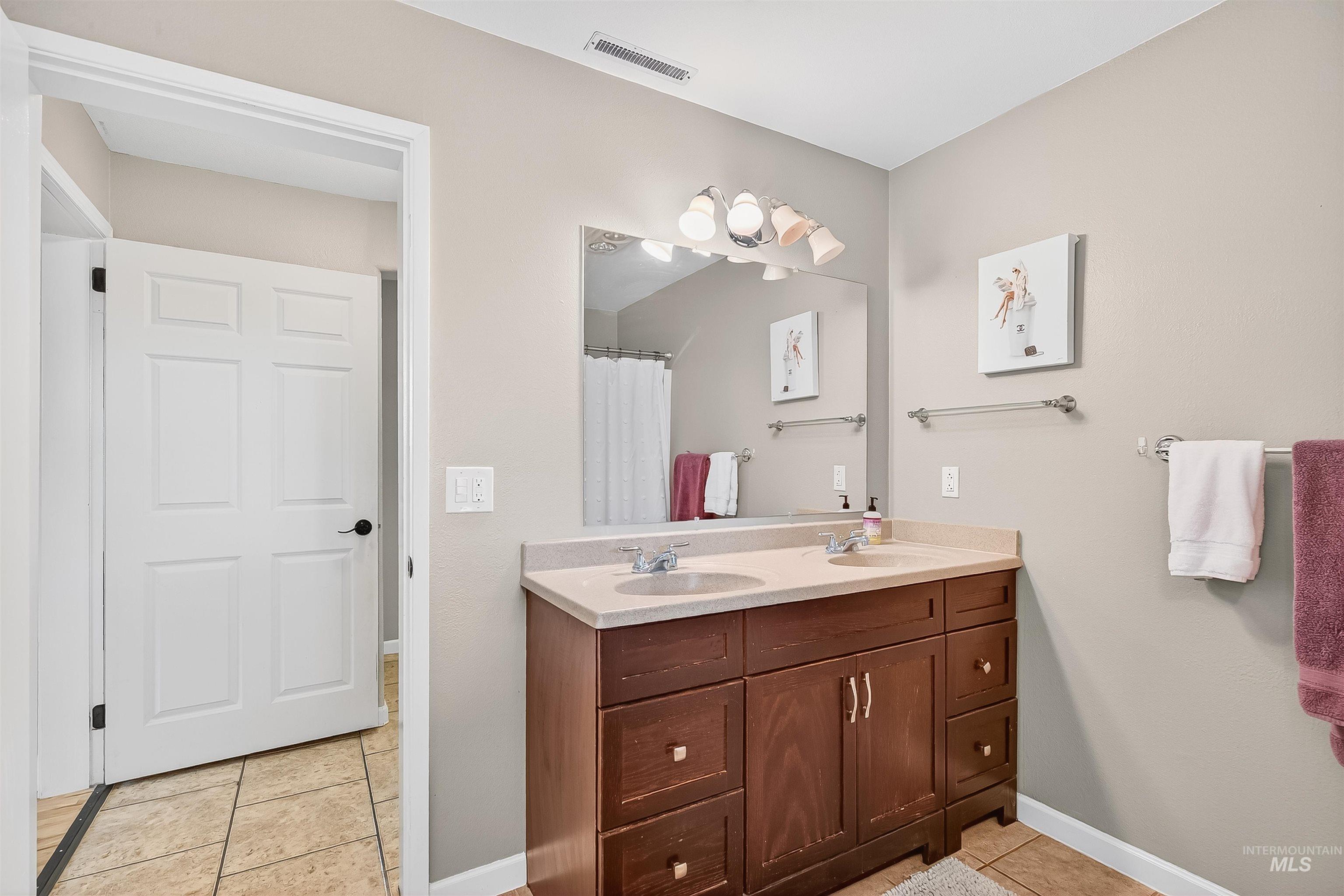 1220 Birch Avenue Lewiston, ID 83501 - Photo 31 of 45 Bathroom with light tile patterned floors, double vanity, and a shower with curtain