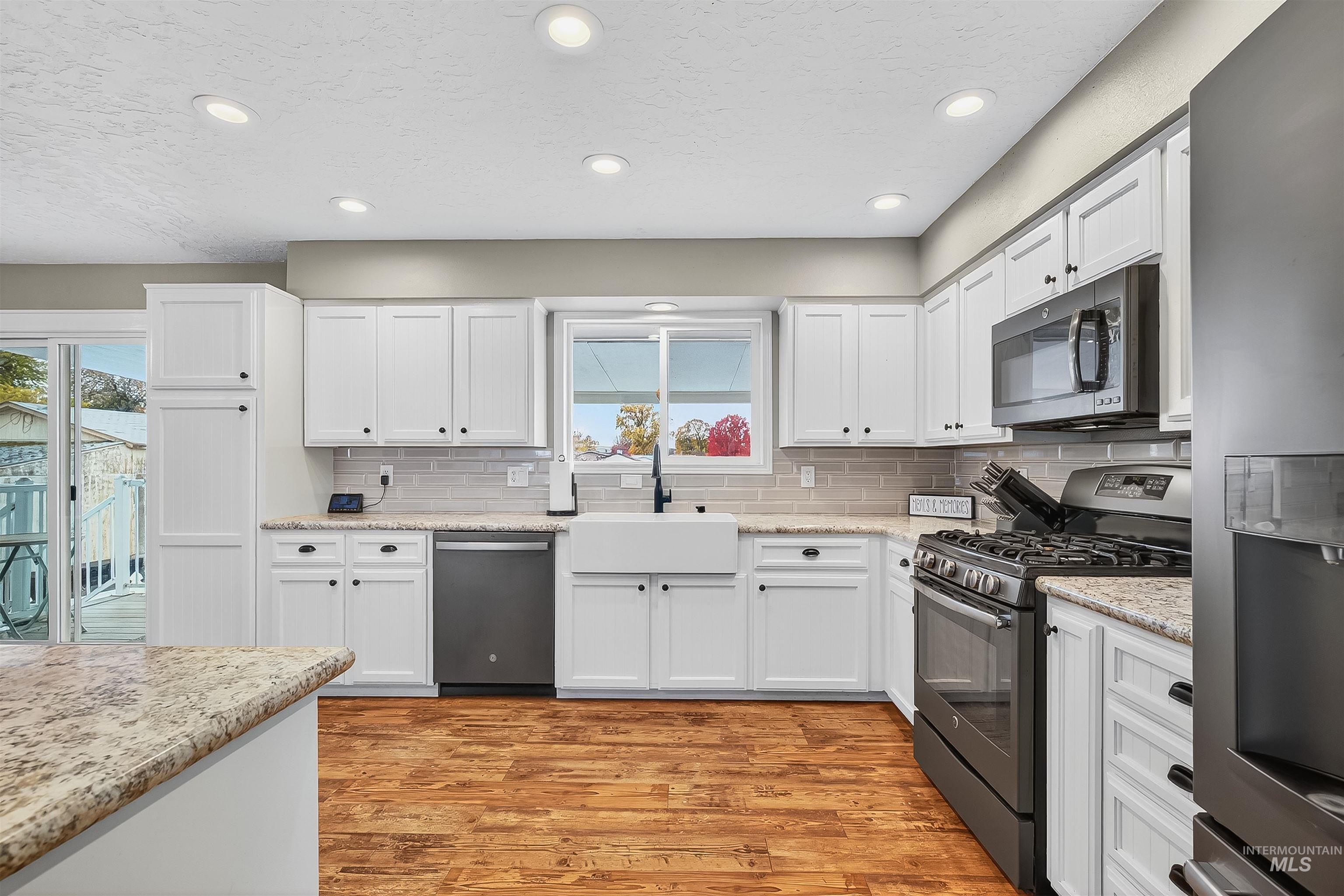1220 Birch Avenue Lewiston, ID 83501 - Photo 6 of 45 Kitchen featuring stainless steel appliances, white cabinetry, a textured ceiling, recessed lighting, and light wood-style floors
