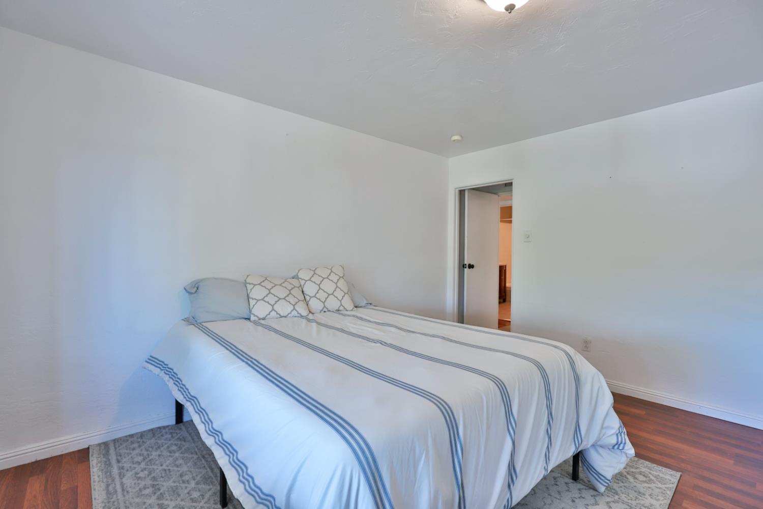 207 Peek Street Jackson, CA 95642 - Photo 15 of 30 a bedroom with a bed and wooden floor