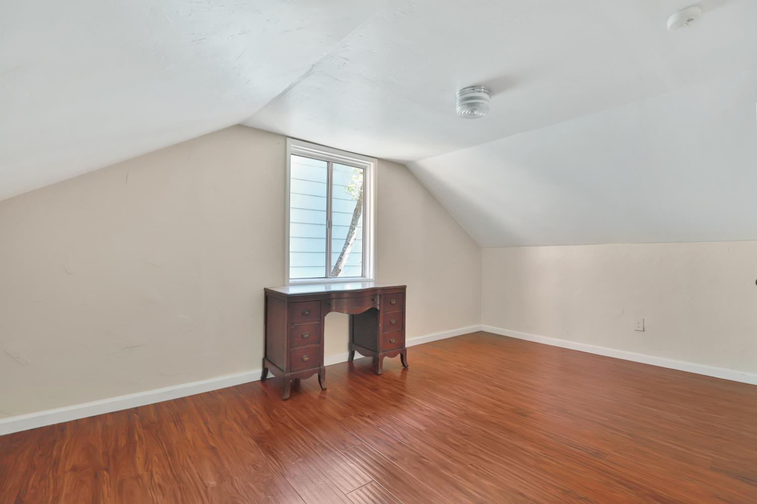 207 Peek Street Jackson, CA 95642 - Photo 19 of 30 an empty room with wooden floor and windows