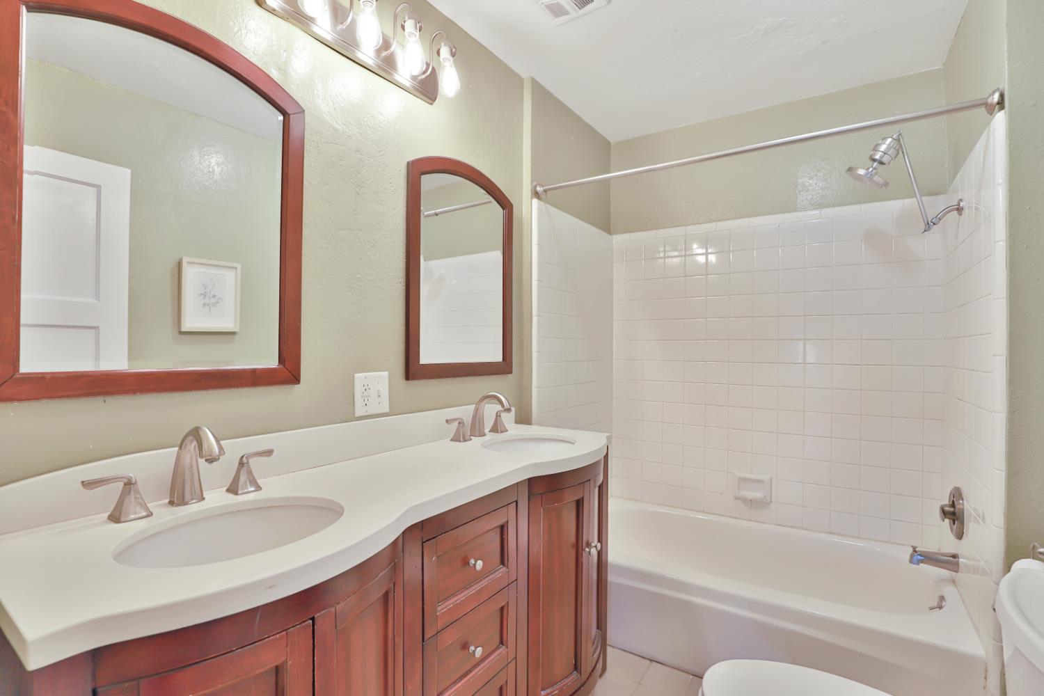207 Peek Street Jackson, CA 95642 - Photo 21 of 30 a bathroom with a tub a sink double vanity and mirror