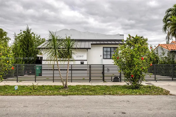 a front view of a house with a garden