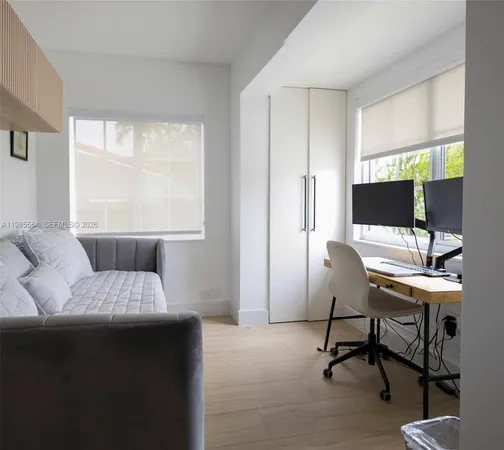 a living room with furniture a flat screen tv and a large window