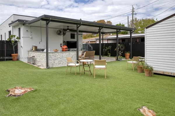 a view of a backyard with a small cabin and wooden fence