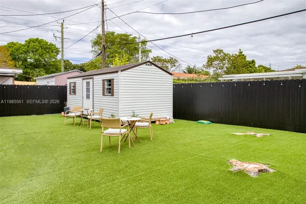 a backyard of a house with table and chairs