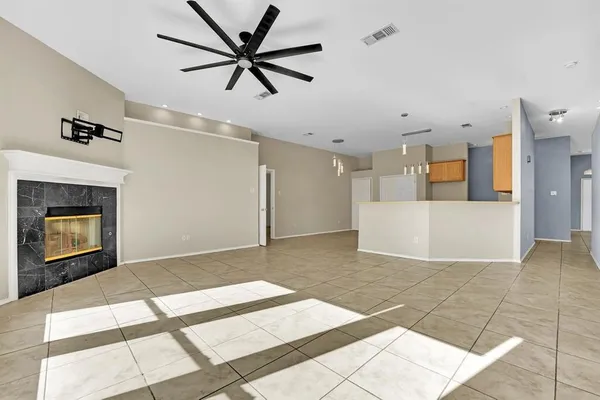 a view of a livingroom with a ceiling fan and kitchen view