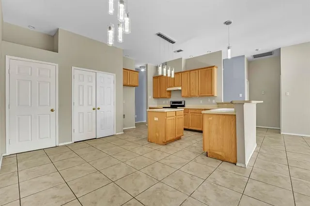 a kitchen with granite countertop a stove a sink and a refrigerator
