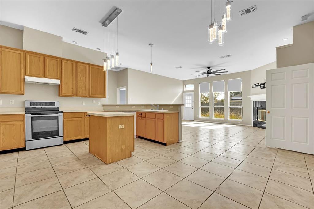 1708 Windcastle Drive Mansfield, TX 76063 - Photo 14 of 28 a kitchen with stainless steel appliances a stove a sink a microwave and cabinets