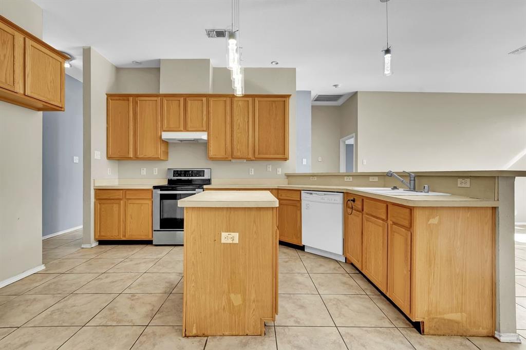 1708 Windcastle Drive Mansfield, TX 76063 - Photo 15 of 28 a kitchen with a sink a stove top oven and cabinets