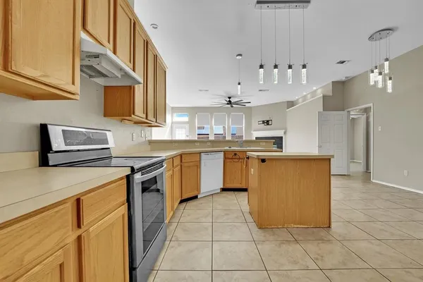 a kitchen with stainless steel appliances granite countertop a sink counter top space cabinets and a stove top oven