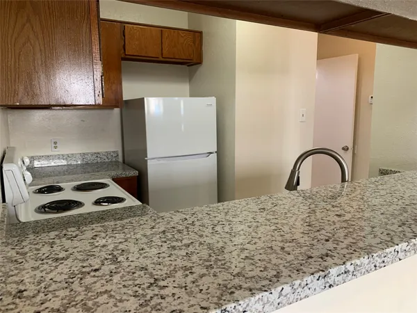 a kitchen with a sink a refrigerator and cabinets
