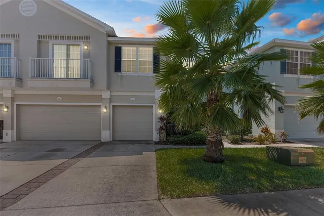a view of a house with a yard and palm trees