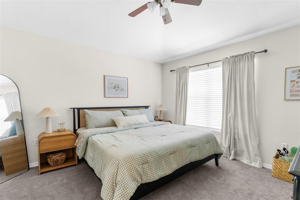 8546 Great Egret Trace New Port Richey, FL 34653 - Photo 12 of 21 a bedroom with a bed and a chandelier