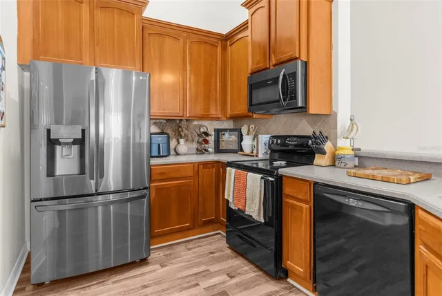 a kitchen with stainless steel appliances granite countertop a refrigerator stove and microwave