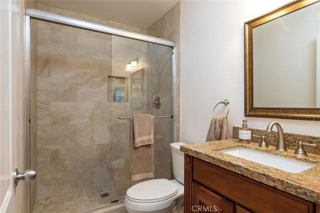 a bathroom with a granite countertop sink toilet and shower