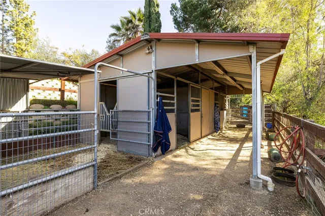 a view of a wooden house with a large window and wooden fence