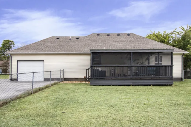 a view of a house with a yard and wooden fence