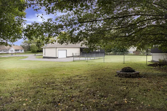a backyard of a house with lots of green space and fountain