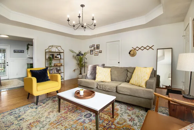a living room with furniture and a chandelier