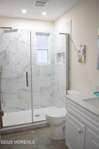 a bathroom with a shower a toilet and a shower
