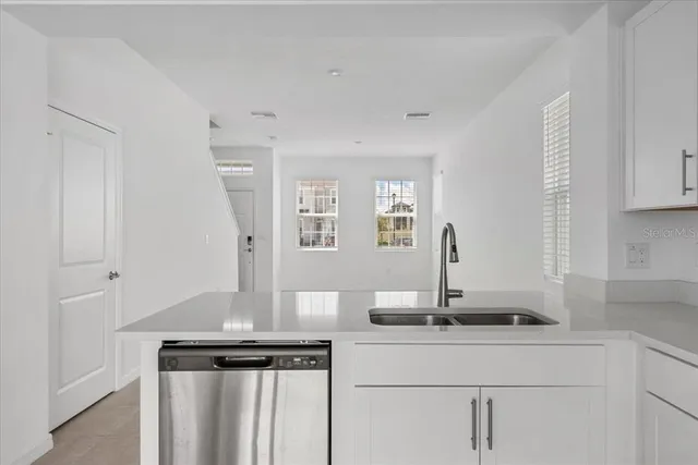 a view of kitchen with cabinets and window