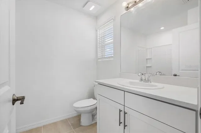a bathroom with a granite countertop sink mirror and toilet