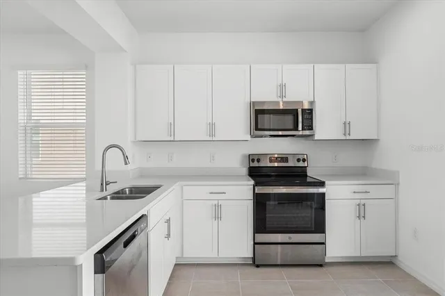 a kitchen with white cabinets and stainless steel appliances