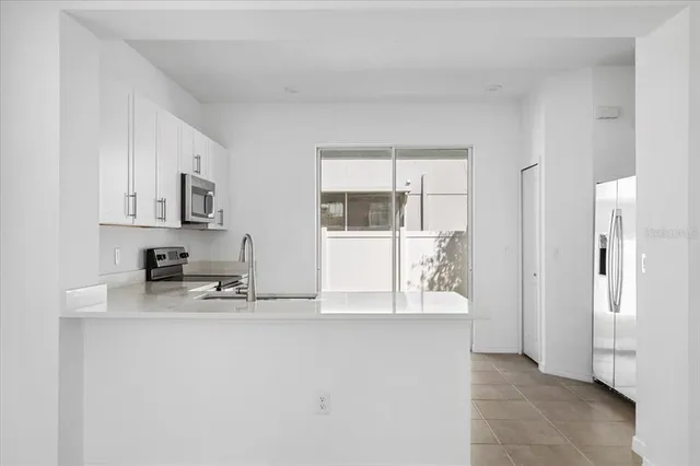 a kitchen with stainless steel appliances a refrigerator and a stove top oven