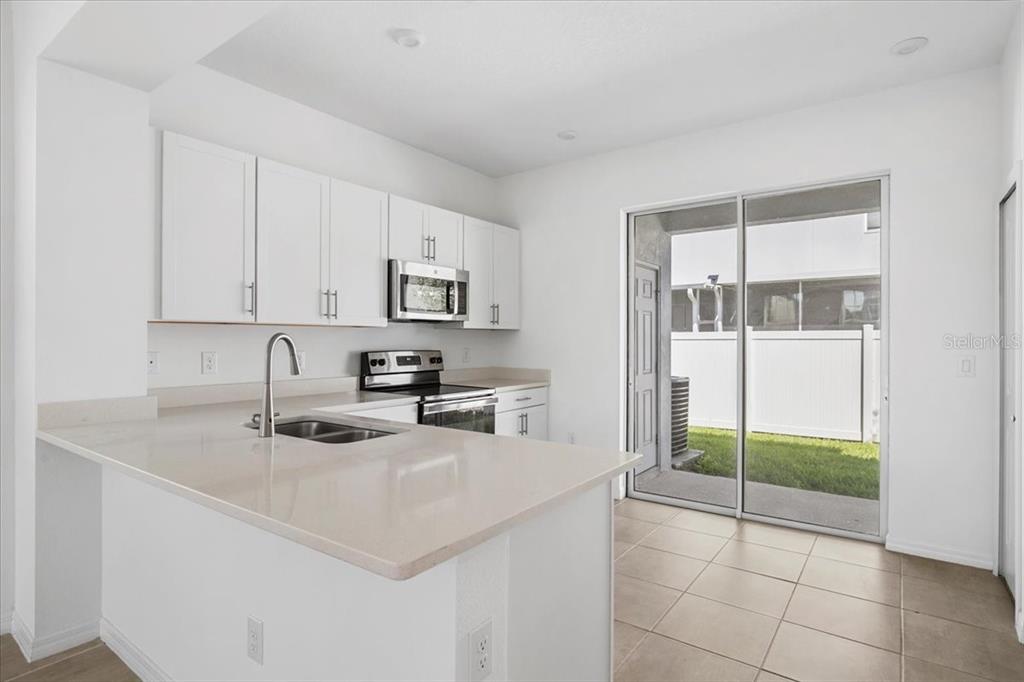 6338 Fairmont Lane Palmetto, FL 34221 - Photo 10 of 39 a kitchen with stainless steel appliances granite countertop a stove a sink and a refrigerator