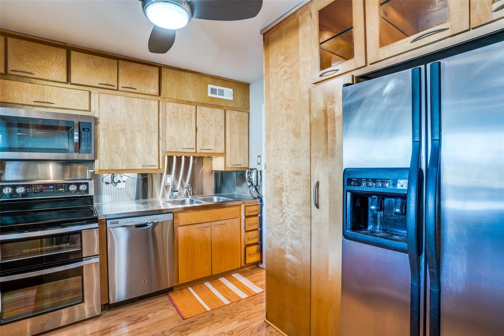 a kitchen with stainless steel appliances granite countertop a refrigerator and a stove