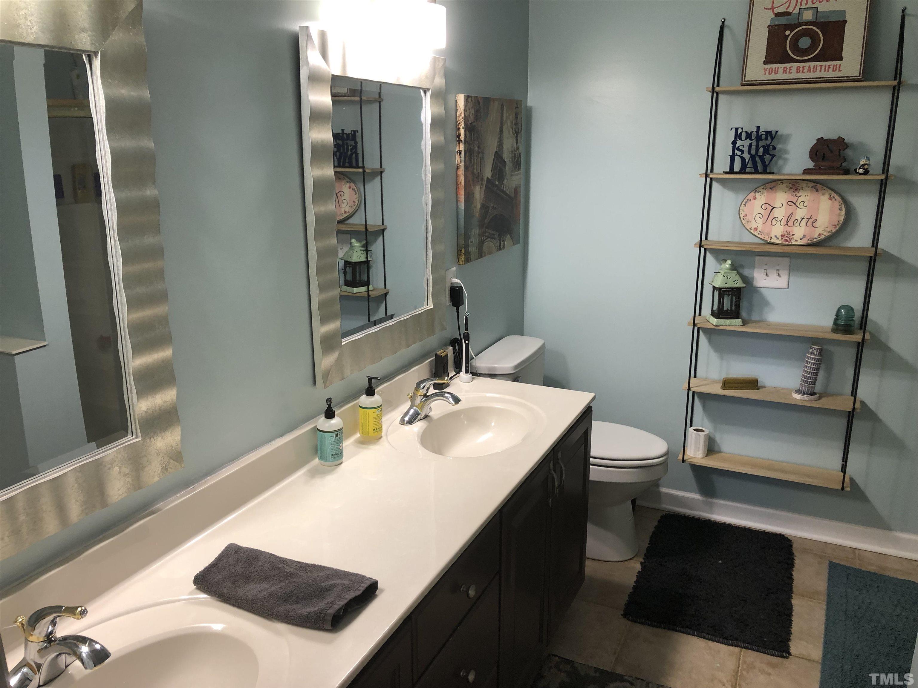 437 Seastone Street Raleigh, NC 27603 - Photo 15 of 30 a bathroom with a sink vanity granite and a mirror