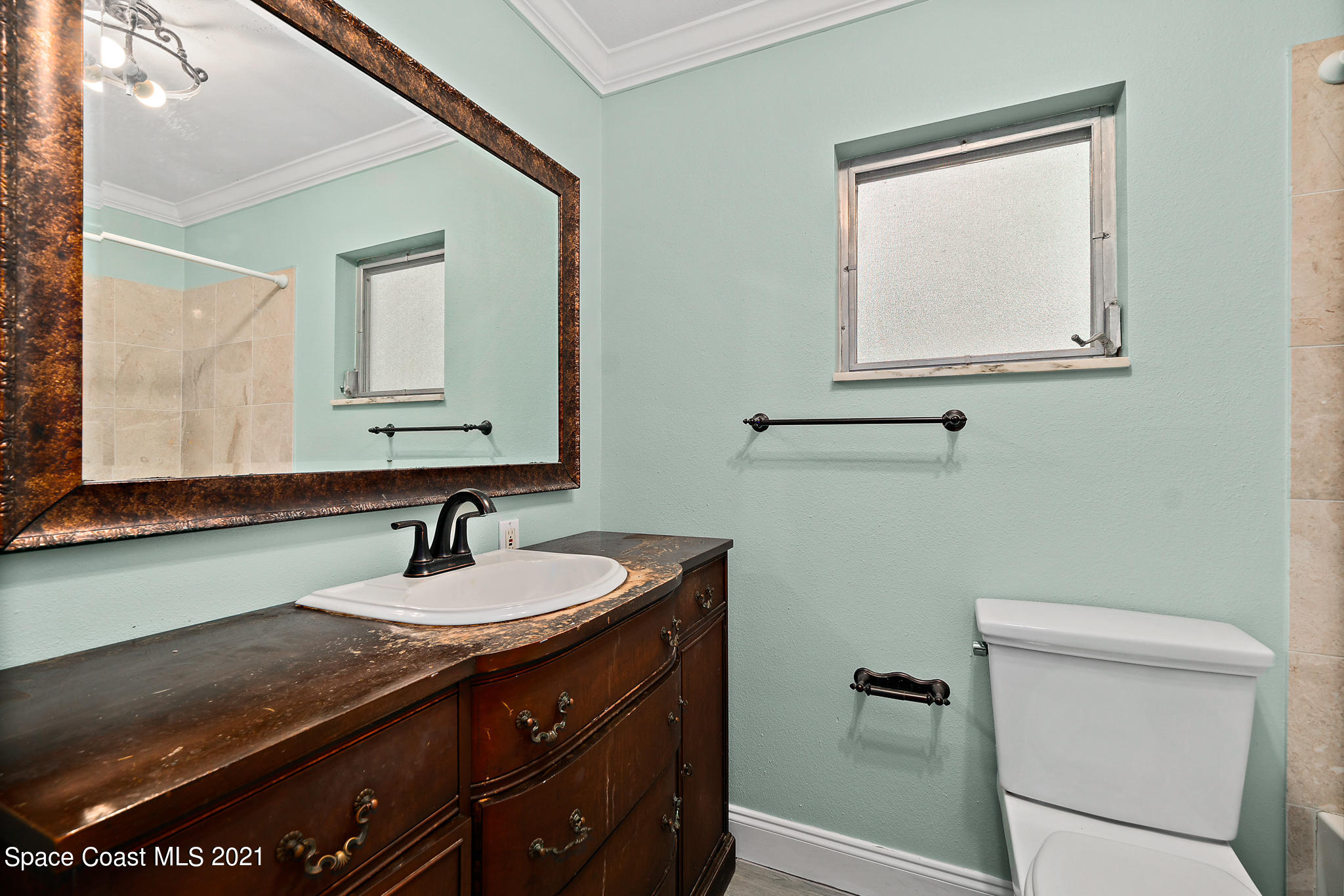 6686 Flamingo Road Melbourne Village, FL 32904 - Photo 18 of 30 a bathroom with a sink a toilet and mirror