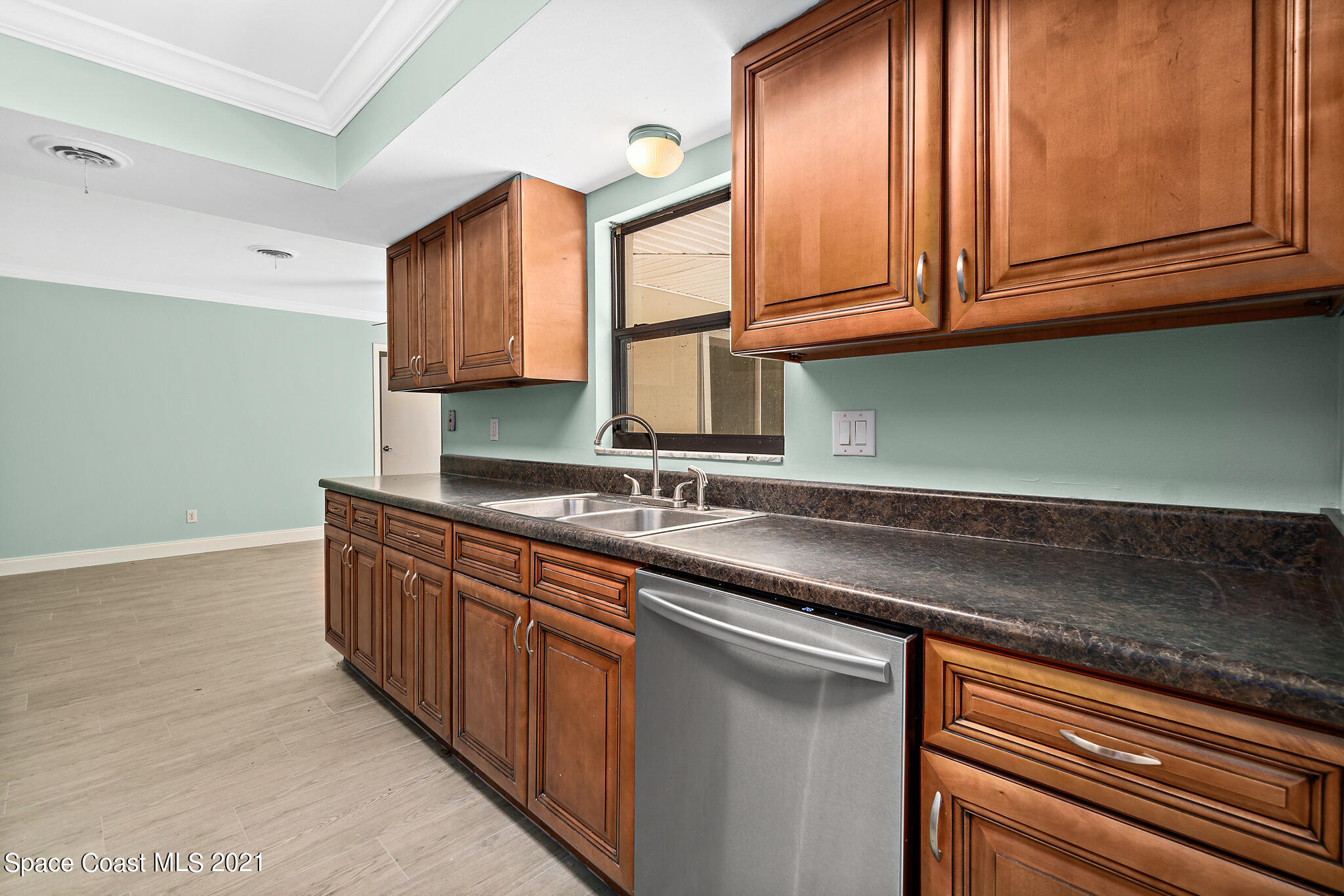 6686 Flamingo Road Melbourne Village, FL 32904 - Photo 10 of 30 a kitchen with stainless steel appliances granite countertop a sink and cabinets with wooden floor