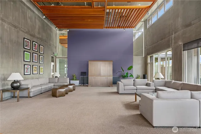 a dining hall with couches a dining table and chairs with wooden floor