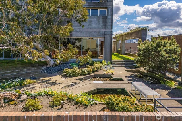 a front view of a building with a garden and plants