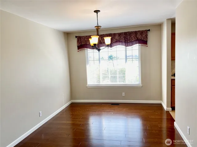 a view of a room with wooden floor chandelier