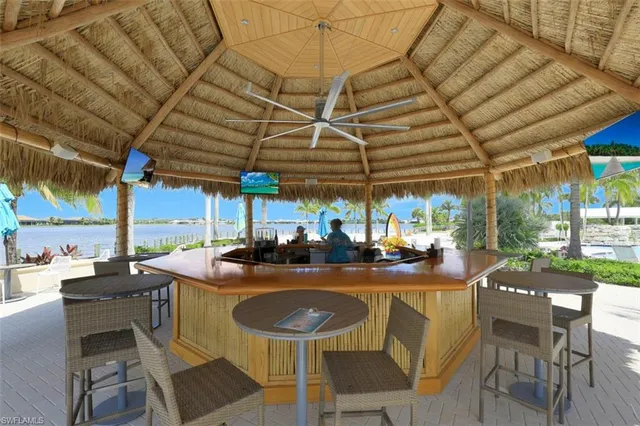 a view of a brick house with plants and large tree